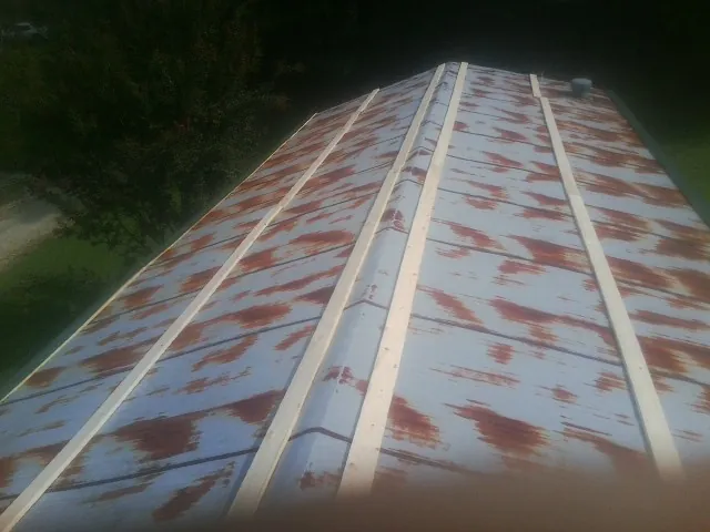 Rusted metal roof panels with new wood purlins before replacement — Storm Damage Roof Repair in Gilberton by Roofing Brothers