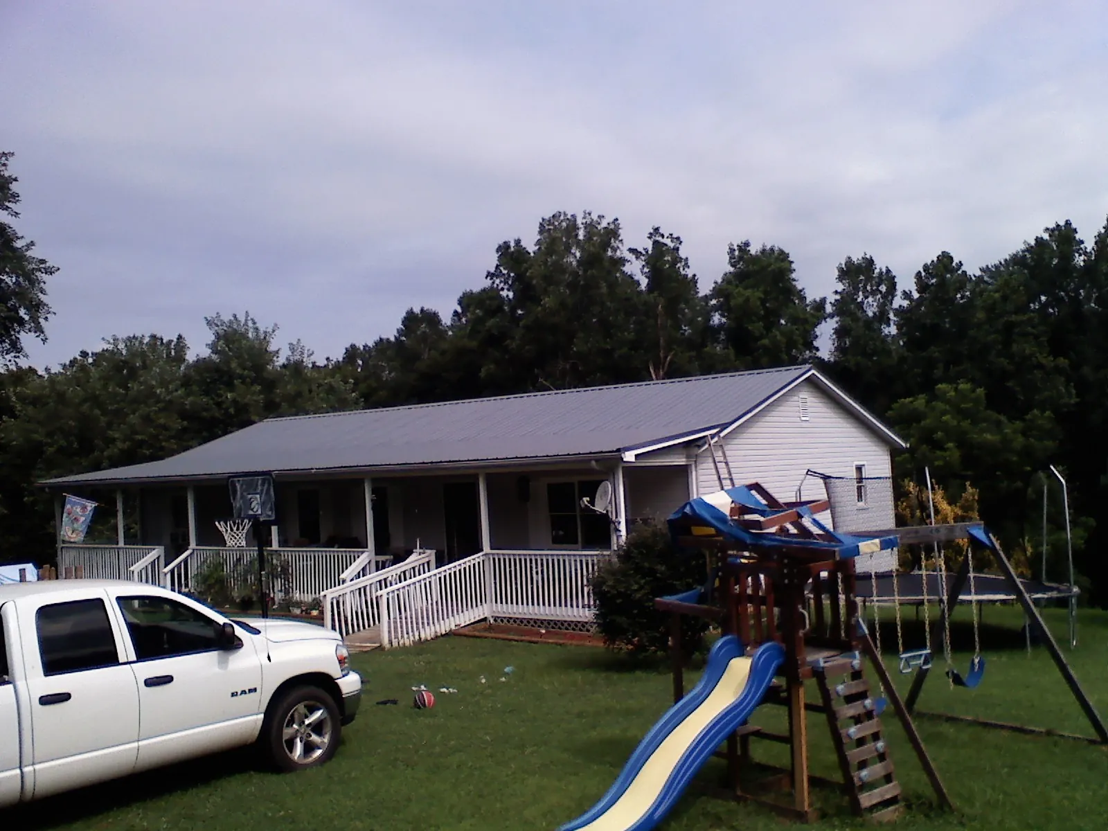 Dark metal roof on a country home with a full length front porch in Gilberton