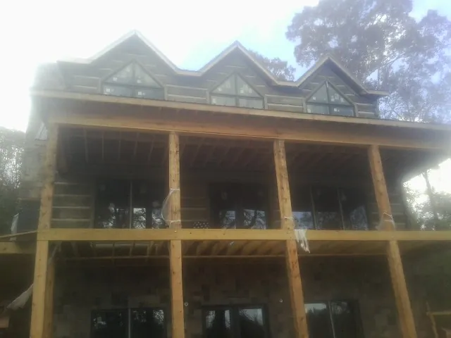 Dormers and porch framing on a large log home under construction — Roof Coating work by our crew in Gilberton