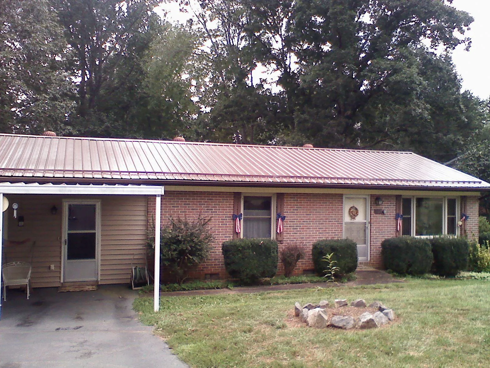 Bronze metal roof and carport on a brick ranch home — Roof Repair work by our crew in Gilberton